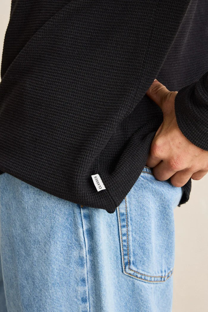 Keel Surf & Supply black waffle knit long sleeve shirt with a textured feel, paired with light wash jeans.