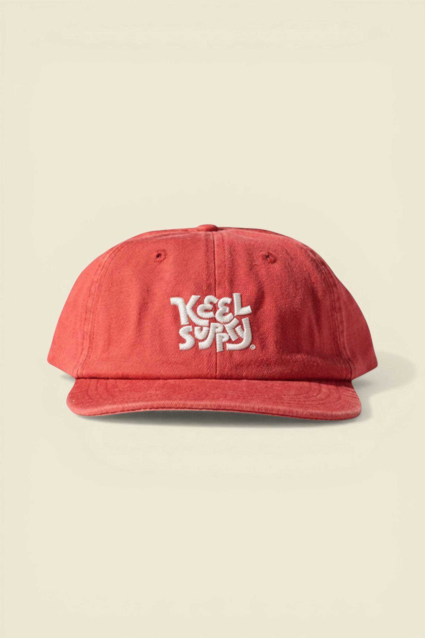 Keel Surf & Supply red cotton twill cap with unstructured peak and white logo embroidery. Adjustable snap closure.