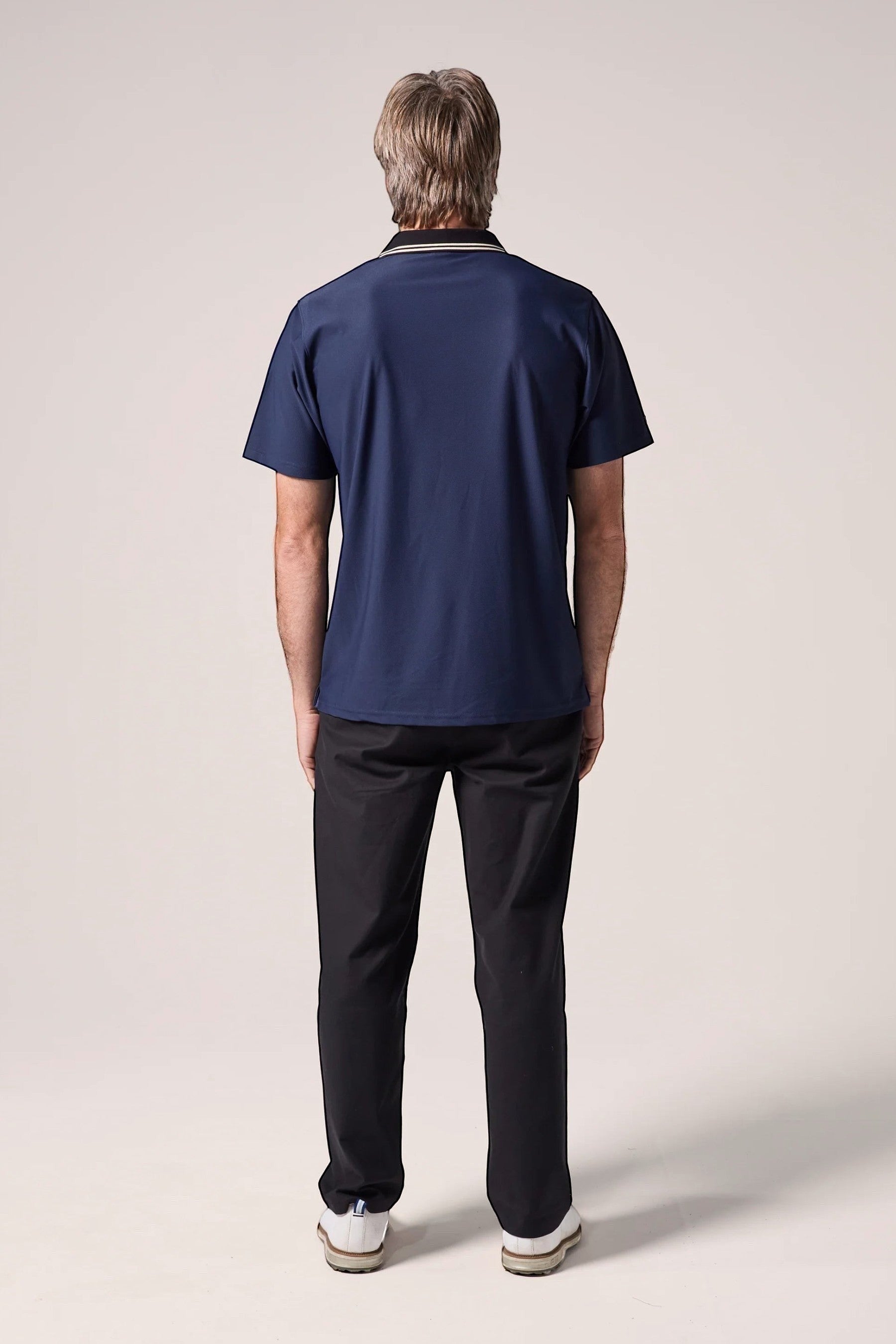 Keel Surf & Supply navy blue polo shirt with black collar featuring white and gold stripes, short sleeves, and embroidered logo.