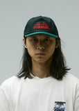 Person wearing a black cap with red text and a white t-shirt against a gray background