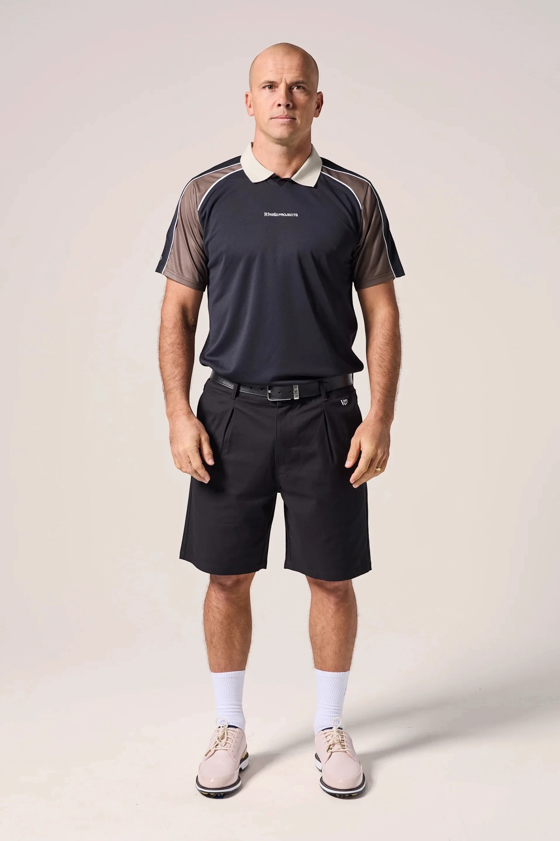 Keel Surf & Supply men's black polo with brown sleeves, zip collar, and white trim. Breathable, stretch fabric.