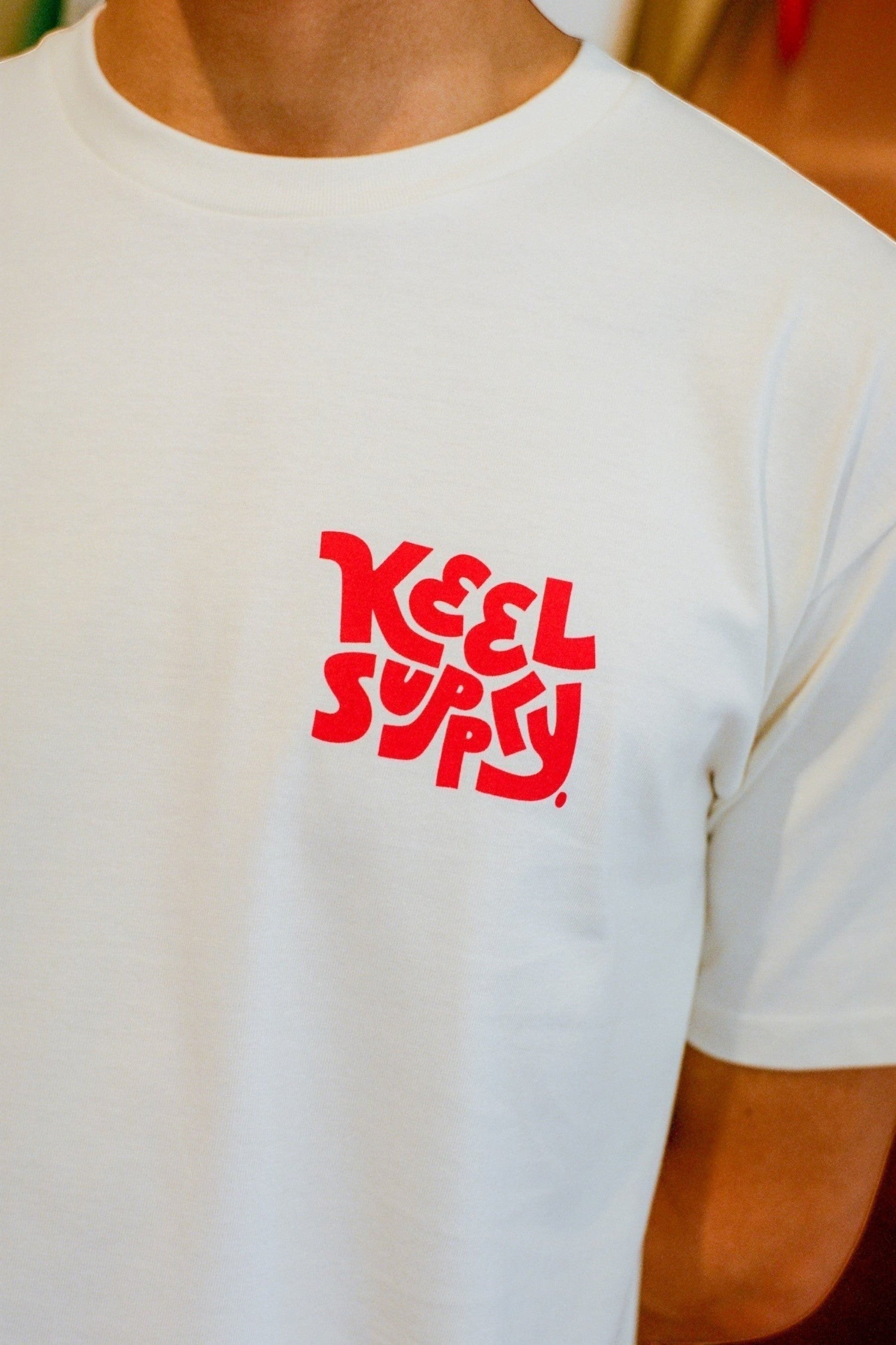 Keel Surf & Supply ecru cotton tee with red graphic logo on chest. Regular fit, short sleeves, crew neck.